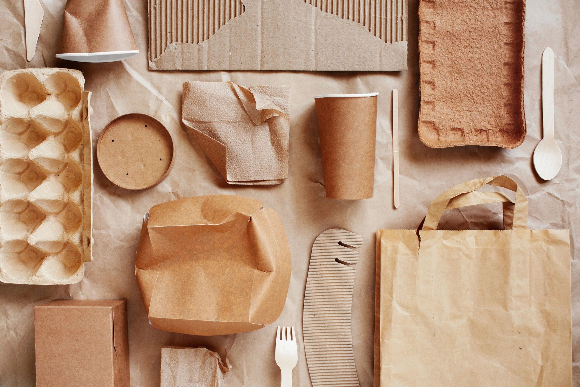 Collection of brown paper products including boxes, bags, and containers on a neutral background.